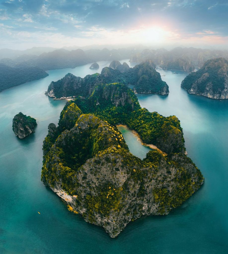 Stunning aerial shot of limestone islets and turquoise waters in Quảng Ninh, Vietnam at sunrise.