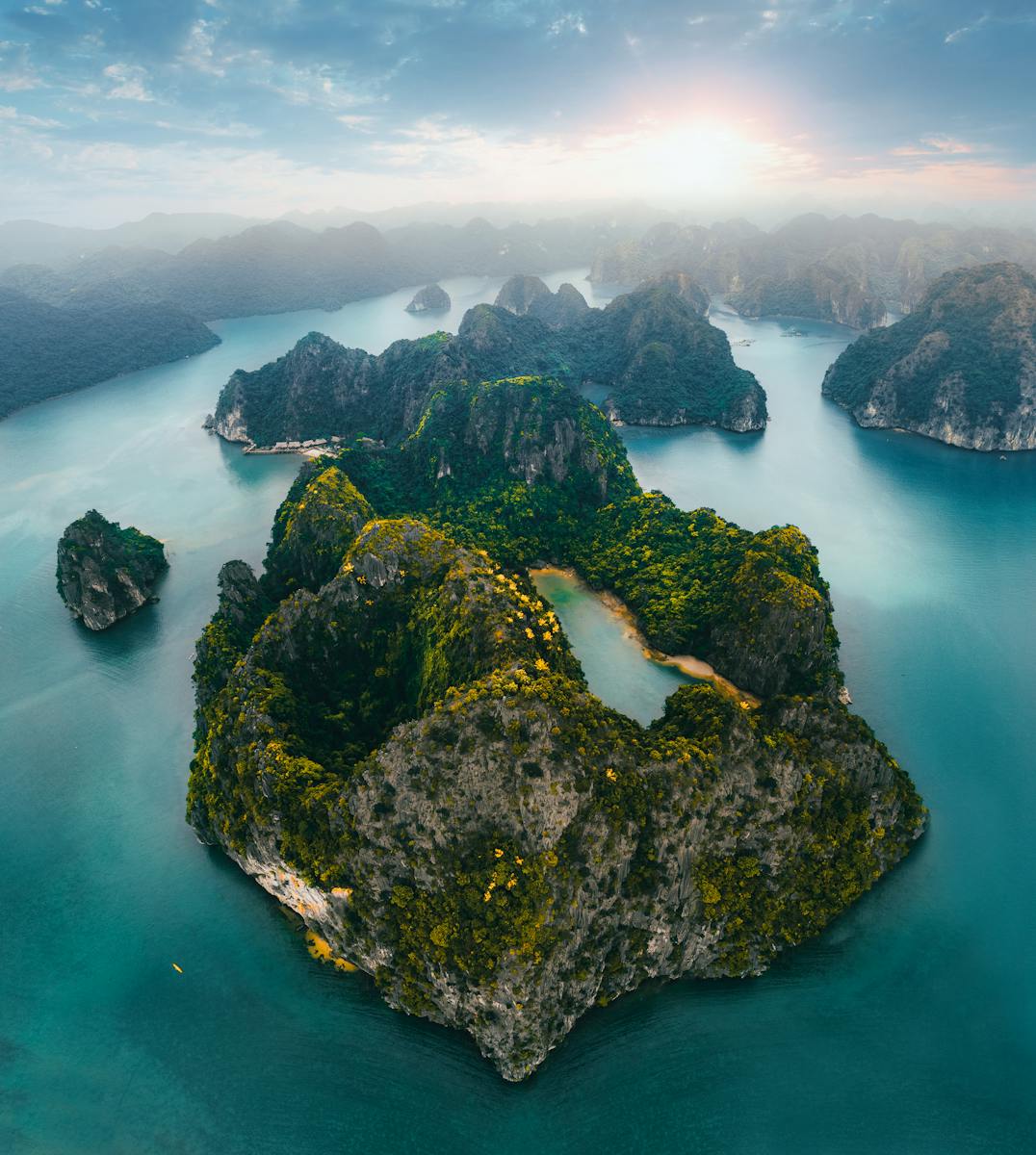 Stunning aerial shot of limestone islets and turquoise waters in Quảng Ninh, Vietnam at sunrise.