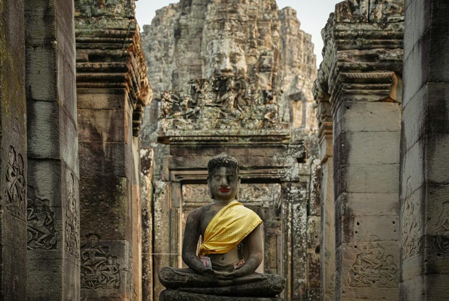Majestic Buddha statue draped in yellow cloth at Bayon Temple, Cambodia.