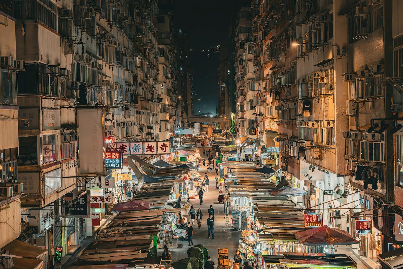 Explore the bustling night market streets of Mong Kok, Hong Kong, illuminated by vivid streetlights.