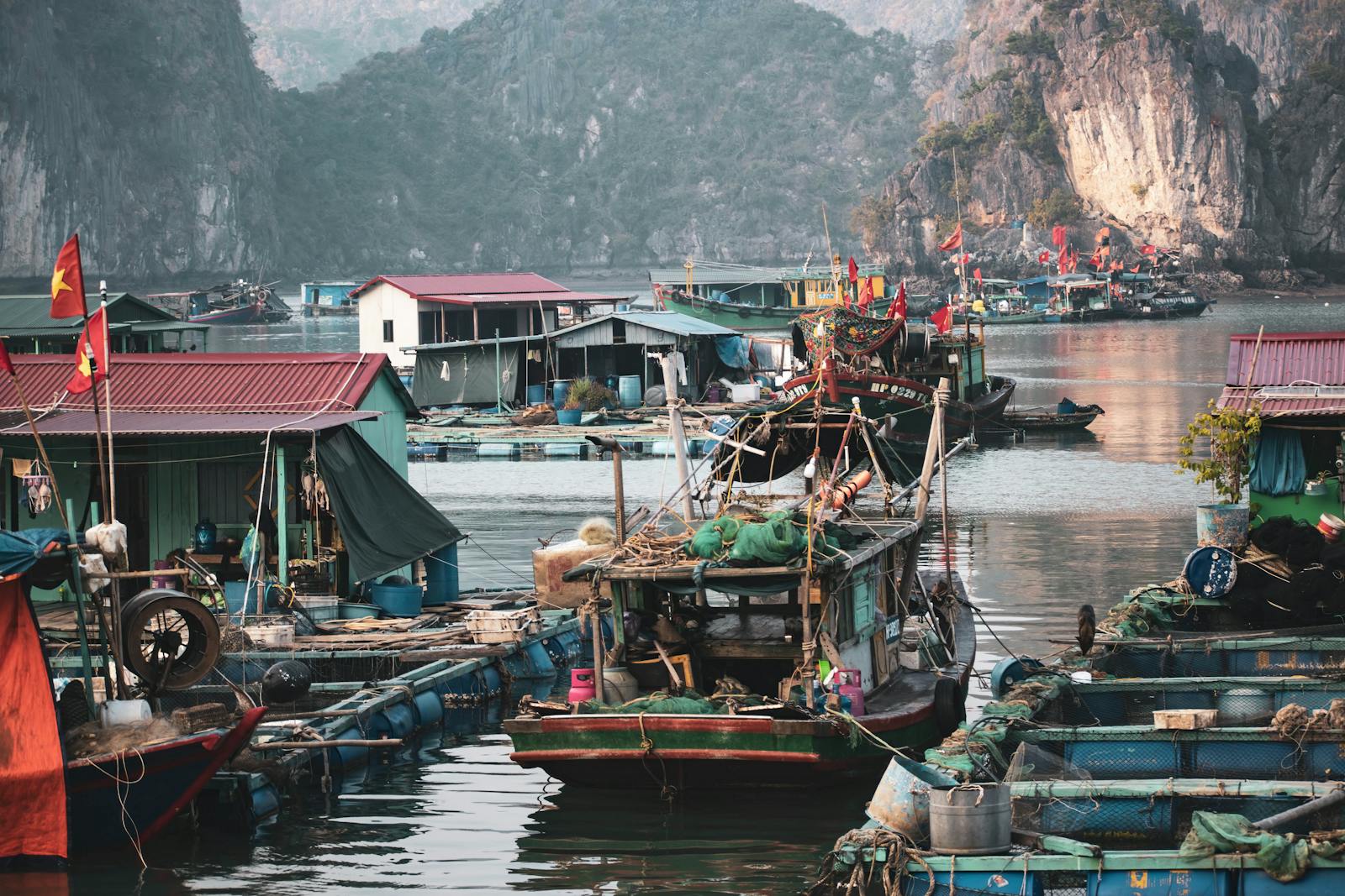 Scenic view of a traditional fishing village in Halong Bay, Vietnam, showcasing vibrant boats and houses.