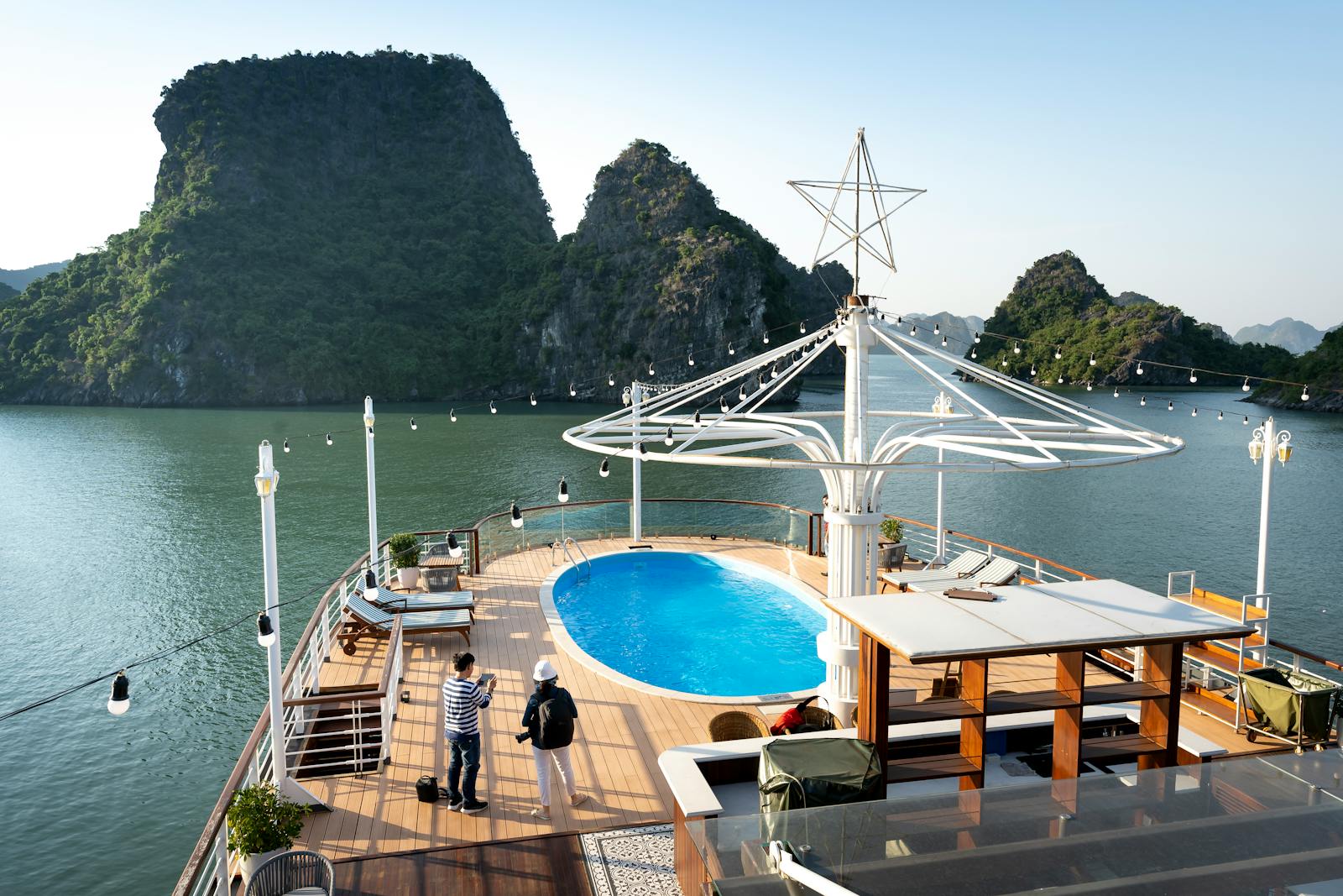 Luxurious yacht with pool cruising in a stunning natural bay, perfect for recreation.
