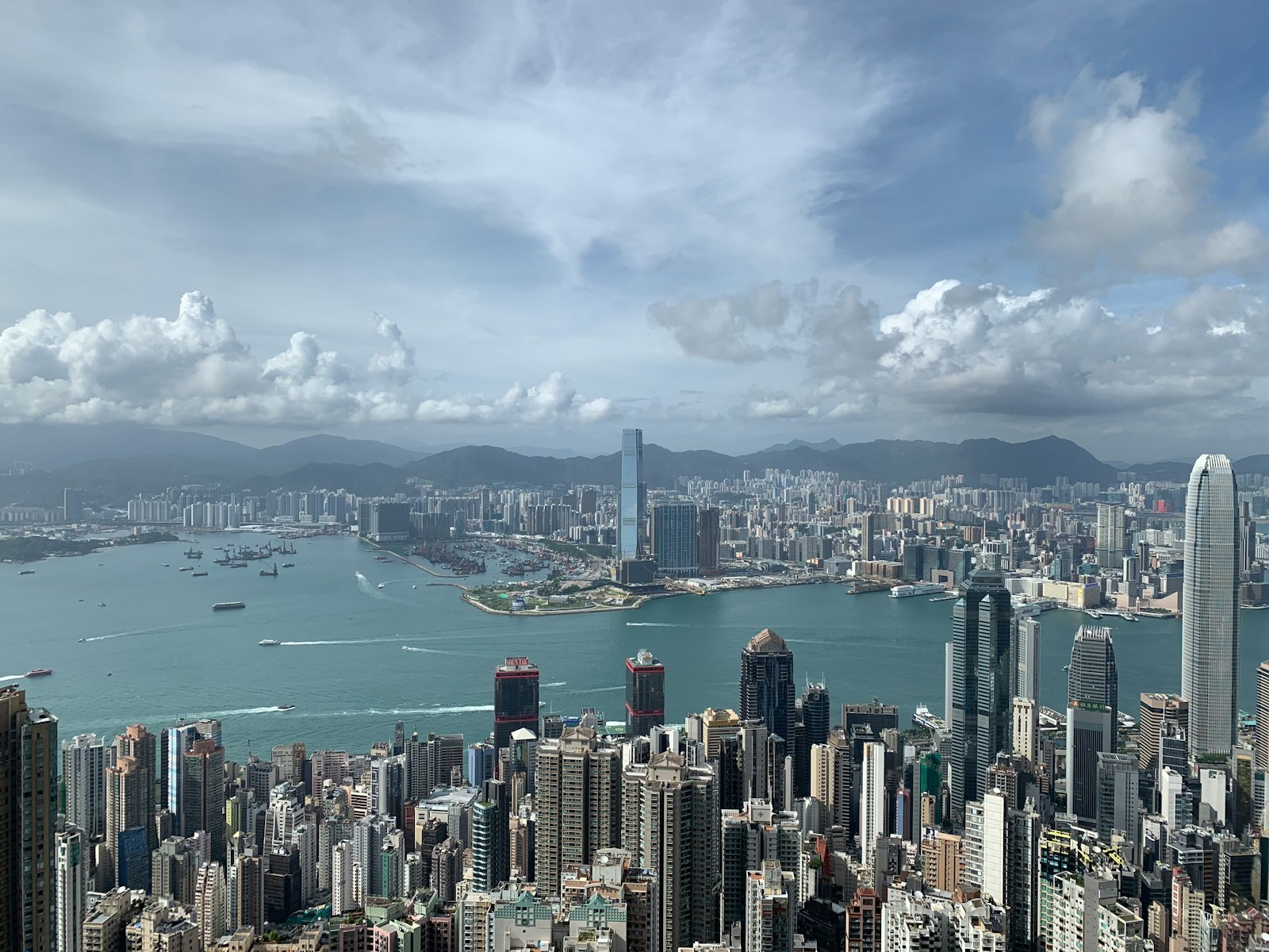 city skyline under white clouds and blue sky during daytime
