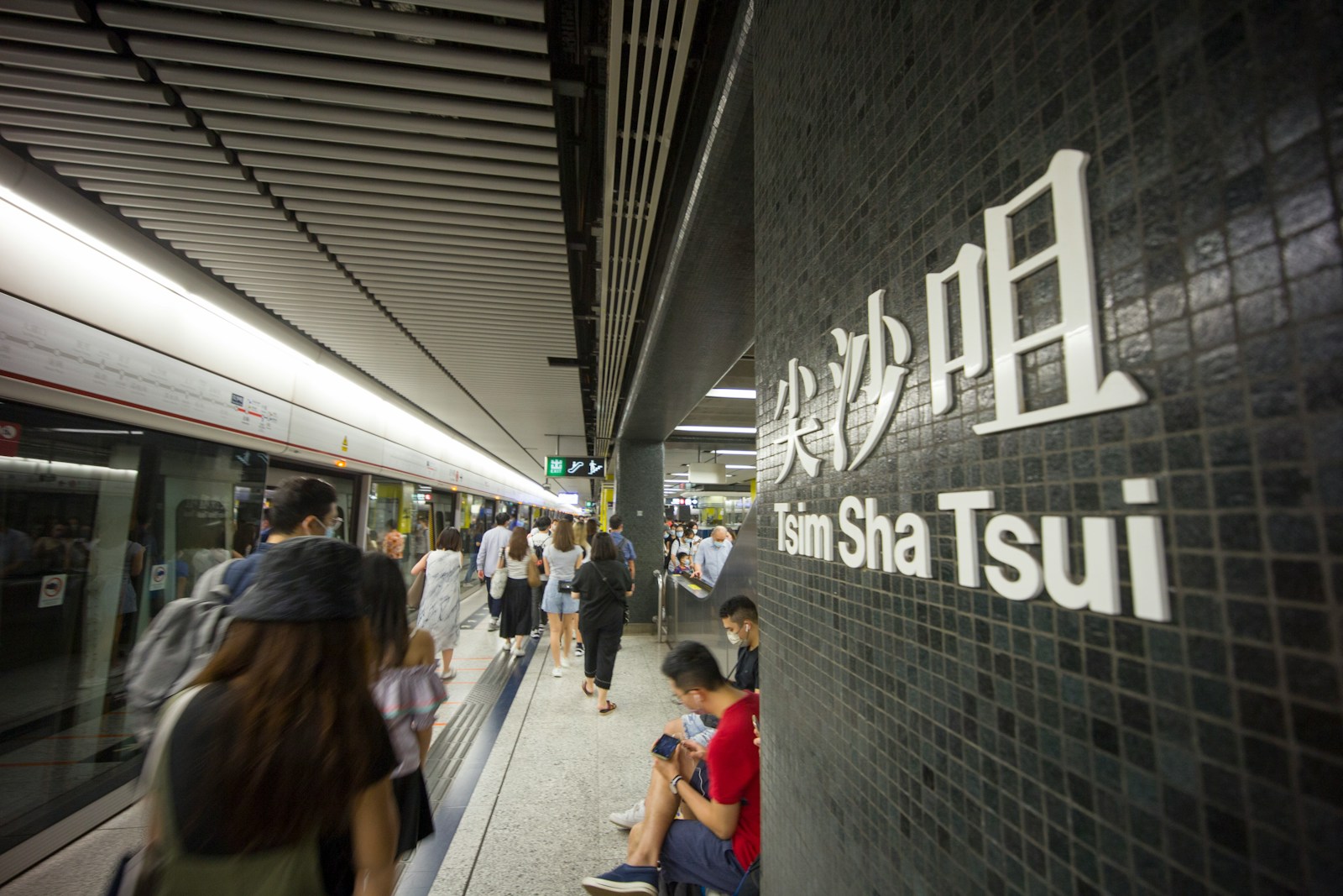 a group of people standing next to a train station