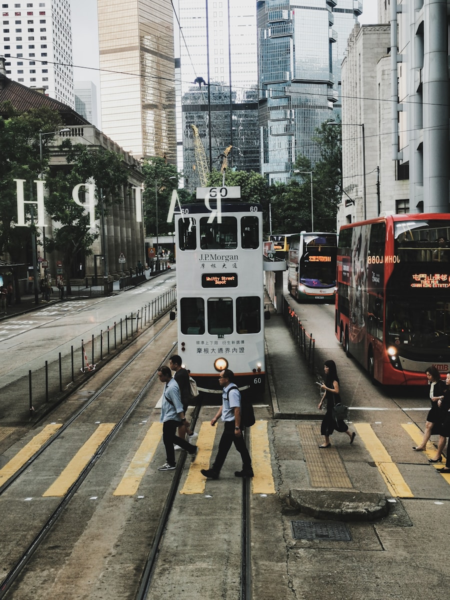 a group of people crossing a street in front of a double decker bus