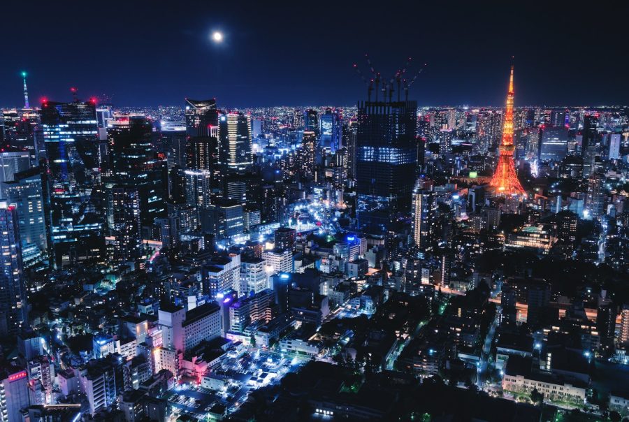 a view of a city at night with the moon in the sky